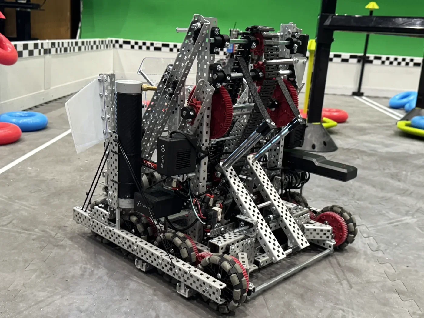 The High Stakes robot on a practice field, with red and blue rings around it
